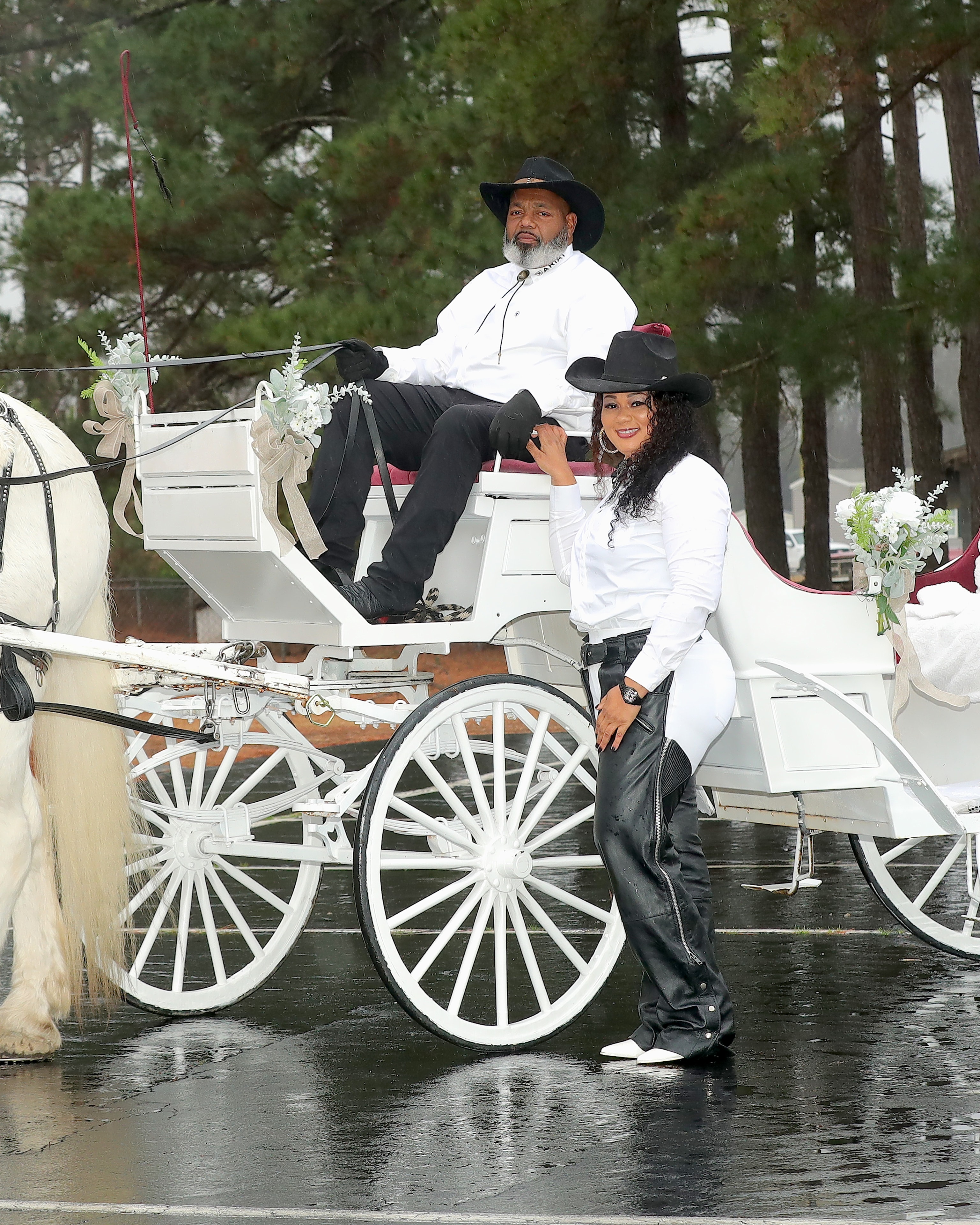 Couple in white carriage with umbrella in a forest setting